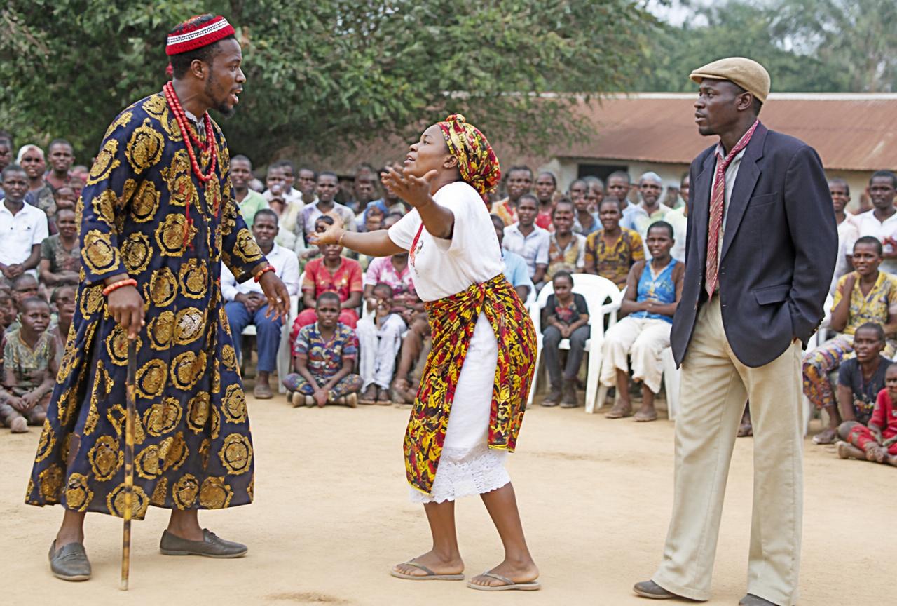 Placeholder photograph: performers staging a play for a seated community audience